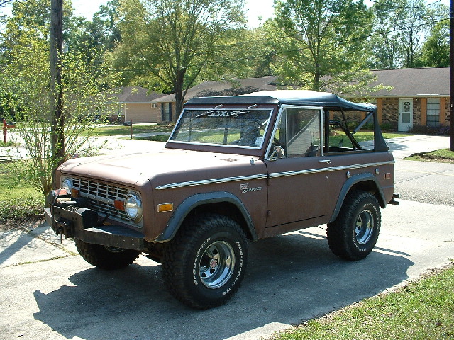Brown SUV with a black soft top and chrome wheels