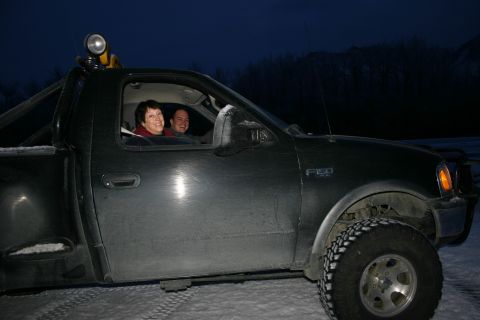 2003 Jeep TJ - A dark grey Ford F-150 is parked in a snowy area at dusk with two occupants visible.