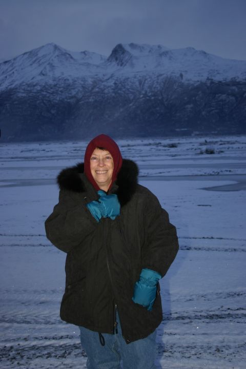 2003 Jeep TJ - A woman stands in a snowy landscape with mountains in the background, likely during a winter excursion.