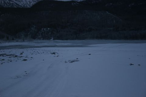 2003 Jeep TJ - A vast, snow-covered landscape under a dim sky, with mountains and trees in the distance.