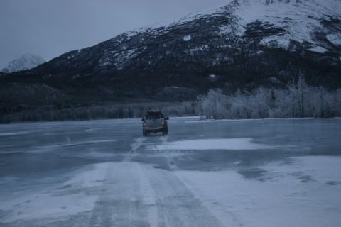 2003 Jeep TJ - SUV driving on ice near snowy mountains.