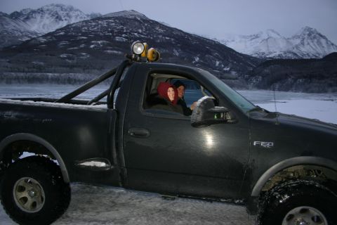 2003 Jeep TJ - A black Ford F-150 pickup truck is parked in a snowy, mountainous area with two people inside.