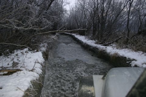 2003 Jeep TJ - Driving through a muddy, icy track in a snowy, wooded area.