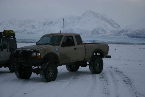 2003 Jeep TJ - Modified Ford Ranger pickup truck in a snowy, mountainous landscape with a glacier visible.