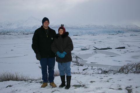 2003 Jeep TJ - A man and a woman pose for a photo in a cold, wintery environment with a large glacier behind them.