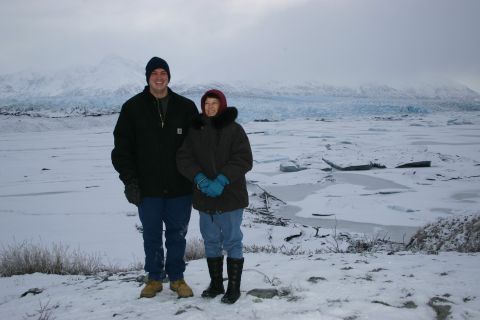 2003 Jeep TJ - A couple poses for a photo in a snowy, glacial environment, with mountains and ice formations visible in the distance.