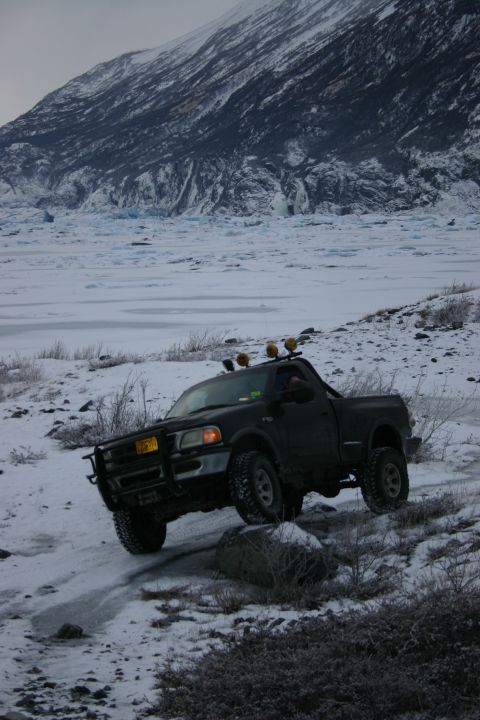 2003 Jeep TJ - Pickup truck navigates icy terrain with a glacier in the background.
