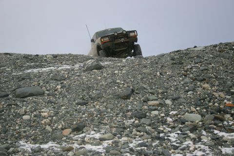 2003 Jeep TJ - Jeep TJ navigating challenging off-road terrain on a rocky, snow-dusted hill.