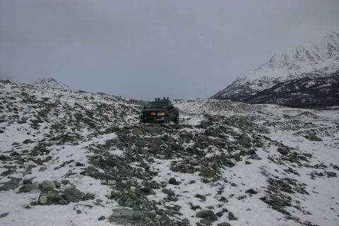 2003 Jeep TJ - SUV navigates a challenging, snow-dusted mountain terrain.