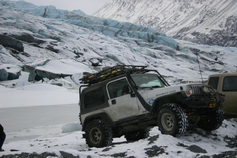 2003 Jeep TJ - A white Jeep Wrangler Rubicon is parked on a snowy surface with a large glacier behind it.