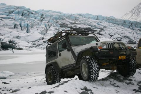 2003 Jeep TJ - A white 2003 Jeep TJ Rubicon navigates snowy terrain with a glacier in the background.