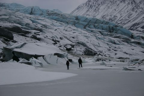 2003 Jeep TJ - A vast glacier dominates the landscape, with two figures dwarfed by its icy expanse.
