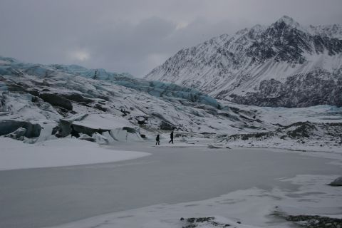 2003 Jeep TJ - A vast, icy landscape with a glacier and snow-capped mountains dominates the scene, with two figures traversing the frozen foreground.