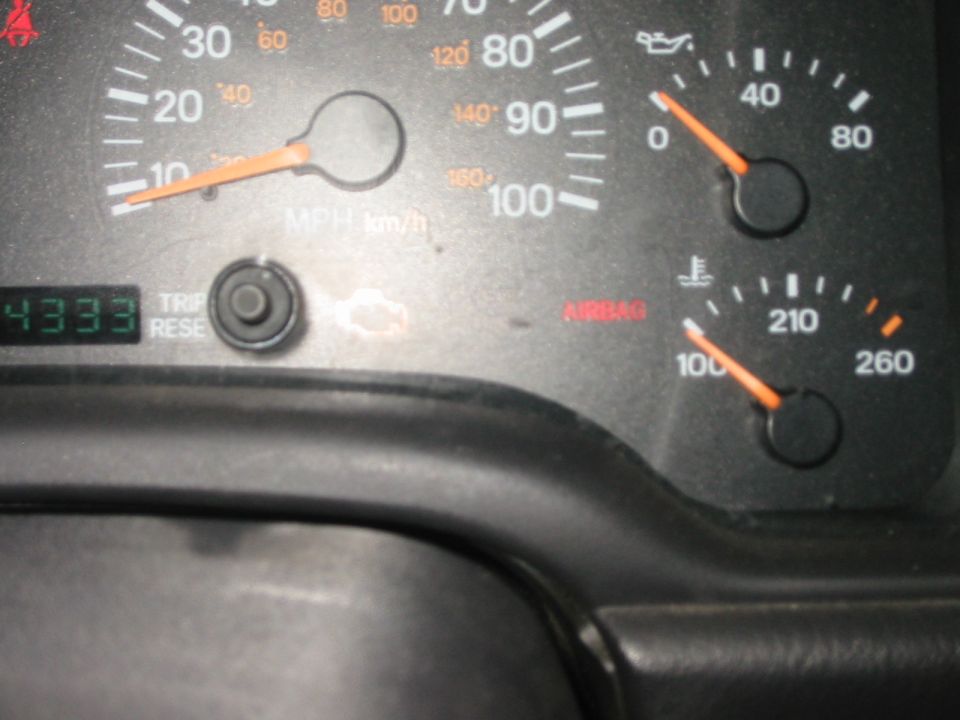 Close-up of a Jeep speedometer, oil and temperature gauges with LCD odometer