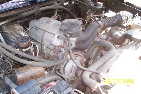 1995 Ford Bronco - The engine bay of a 1995 Ford Bronco shows its V8 engine, alternator, and air intake system.
