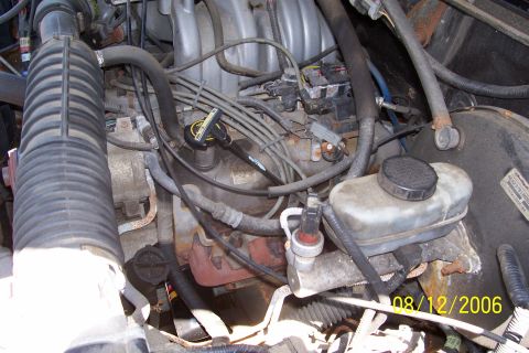 1995 Ford Bronco - Close-up view of a vehicle's engine bay, showing various components including the brake fluid reservoir and air intake system.