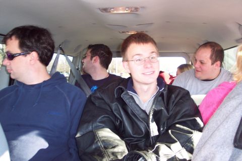 2001 Ford Crown Victoria - Several people are seated inside a van, with the focus on a young man in a leather jacket.