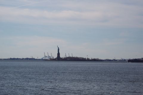 2001 Ford Crown Victoria - View of the Statue of Liberty and New York Harbor with industrial cranes visible.