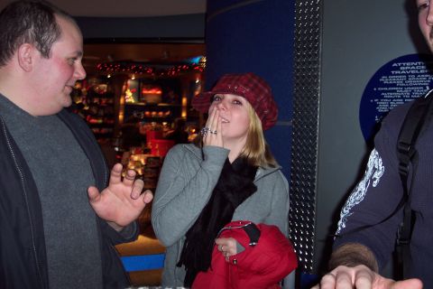 2001 Ford Crown Victoria - People gathered inside a store, with one woman reacting with surprise or amusement.