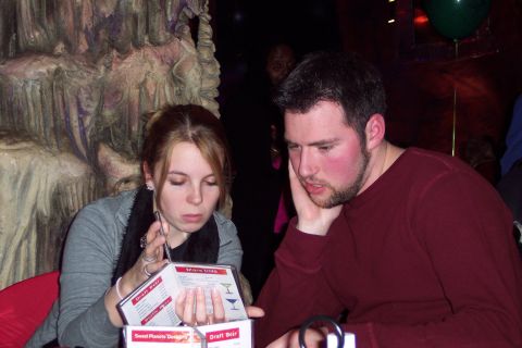 2001 Ford Crown Victoria - A couple studies a menu in a restaurant, with a shadowy figure in the background.