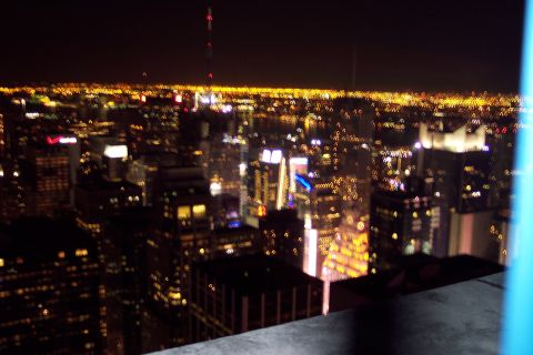 2001 Ford Crown Victoria - A nighttime cityscape of New York City, with countless lights from buildings stretching to the horizon.