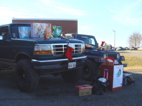 1996 Ford Bronco - Two vehicles, a 1996 Ford Bronco and a Jeep Wrangler, are decorated with Christmas gifts for a toy drive.
