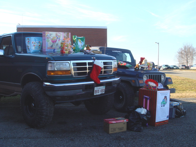 1996 Ford Bronco and a Jeep Wrangler parked side-by-side, both loaded with Christmas gifts and decorations