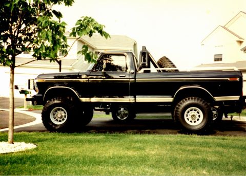 1979 Ford F-250 - This black 1979 Ford F-250 pickup truck is shown from the side, parked on a grassy lawn.