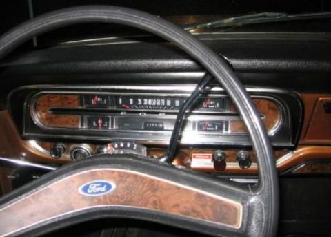 1979 Ford Bronco - The dashboard of a 1978 Ford Bronco shows woodgrain trim and a prominent Ford logo on the steering wheel.