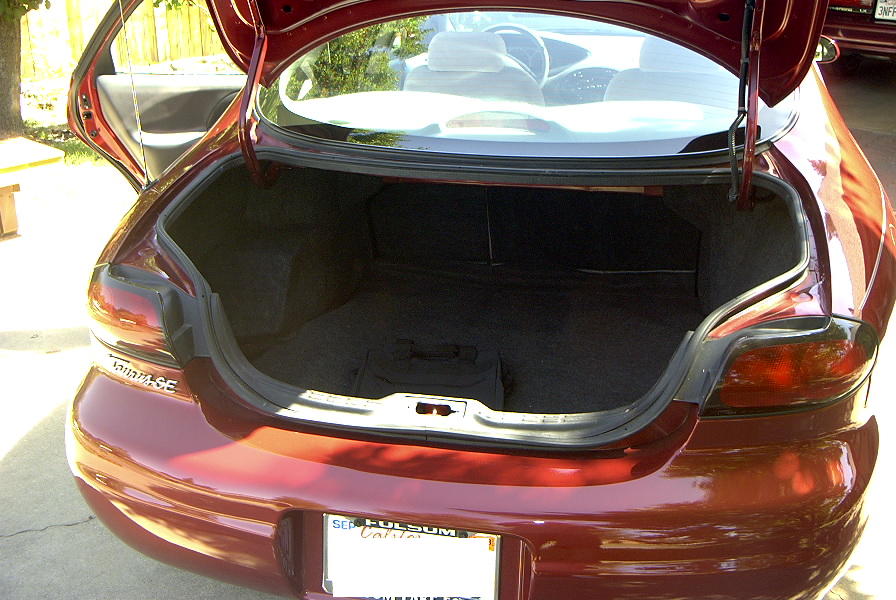 red sedan's open trunk, showing interior and rear bumper with license plate
