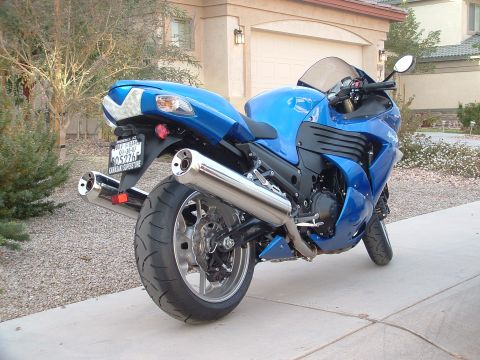 2007 Kawasaki Ninja - A blue sport motorcycle with dual exhaust pipes is parked in front of a house.
