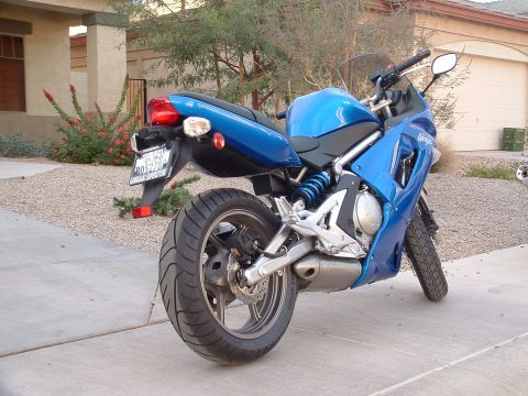 2007 Kawasaki Ninja - A blue Kawasaki Ninja motorcycle is parked on a concrete driveway in front of a house.