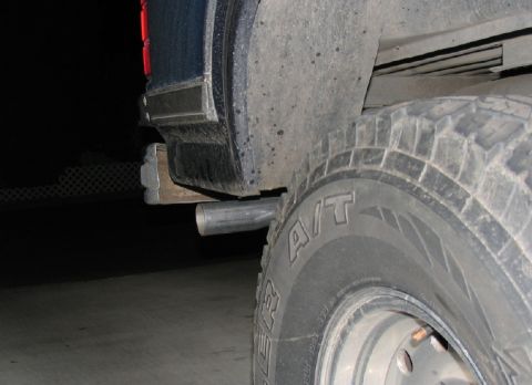 1984 Ford Bronco - Close-up view of a vehicle's rear tire and exhaust pipe.