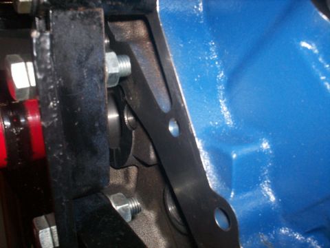1990 Ford Mustang - Detail of an engine block and its attached mounting hardware, with a watermark for SuperMotors.net.