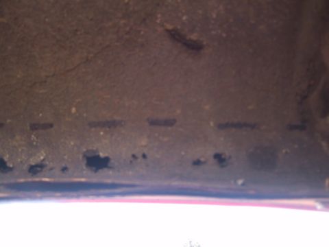 1994 Ford Bronco - Close-up view of the underside of a vehicle, showing signs of rust and wear.