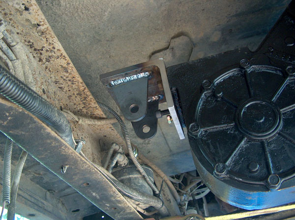 Welded bracket attached to underbody and black component