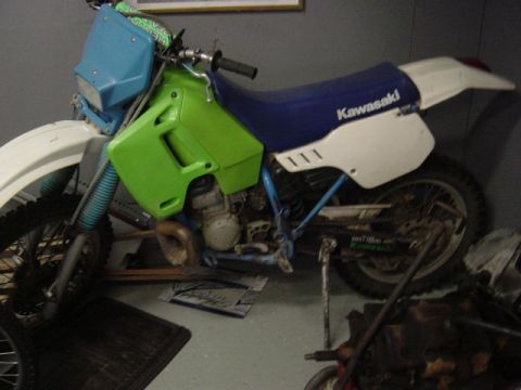 1987 Suzuki Samurai - A side view of a dirt bike with green body panels and a blue seat.