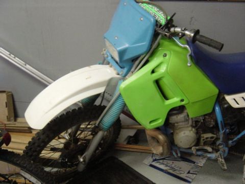 1987 Suzuki Samurai - Front view of a dirt bike with green and blue bodywork, and a white fender.