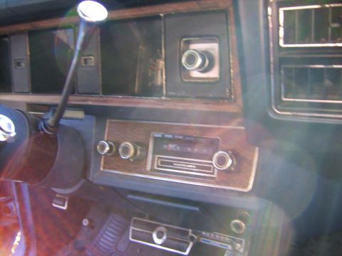 1971 Mercury Marquis - Close-up of a car's dashboard showing the radio and controls, with woodgrain accents.