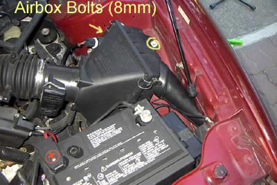 1999 Ford Taurus - Close-up view of a car's engine compartment, focusing on the air filter housing and battery.