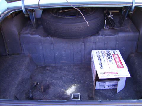 1971 Mercury Marquis - The trunk of a car contains a spare tire, jack, and a box of Motorcraft transmission fluid.