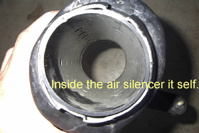 1999 Ford Taurus - Interior view of an air silencer part, showing internal baffles and a hand holding it.