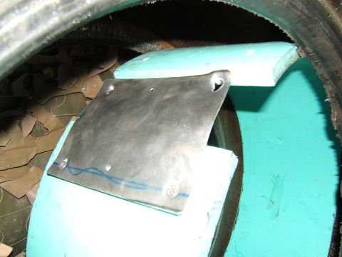 1980 Jeep CJ5 - Close-up of a metal plate with blue lines, mounted on a teal surface, adjacent to a tire.