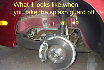1999 Ford Taurus - The underside of a red car shows the wheel well and suspension after the splash guard has been removed.