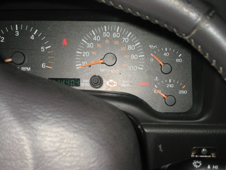Dimly lit Jeep Cherokee gauge cluster and odometer seen past the steering wheel