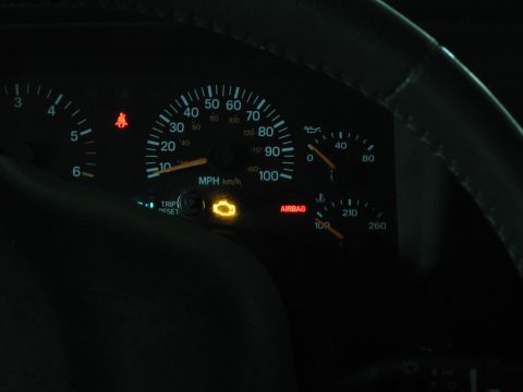 2000 Jeep Cherokee - Dashboard gauges display illuminated check engine and airbag warning lights.