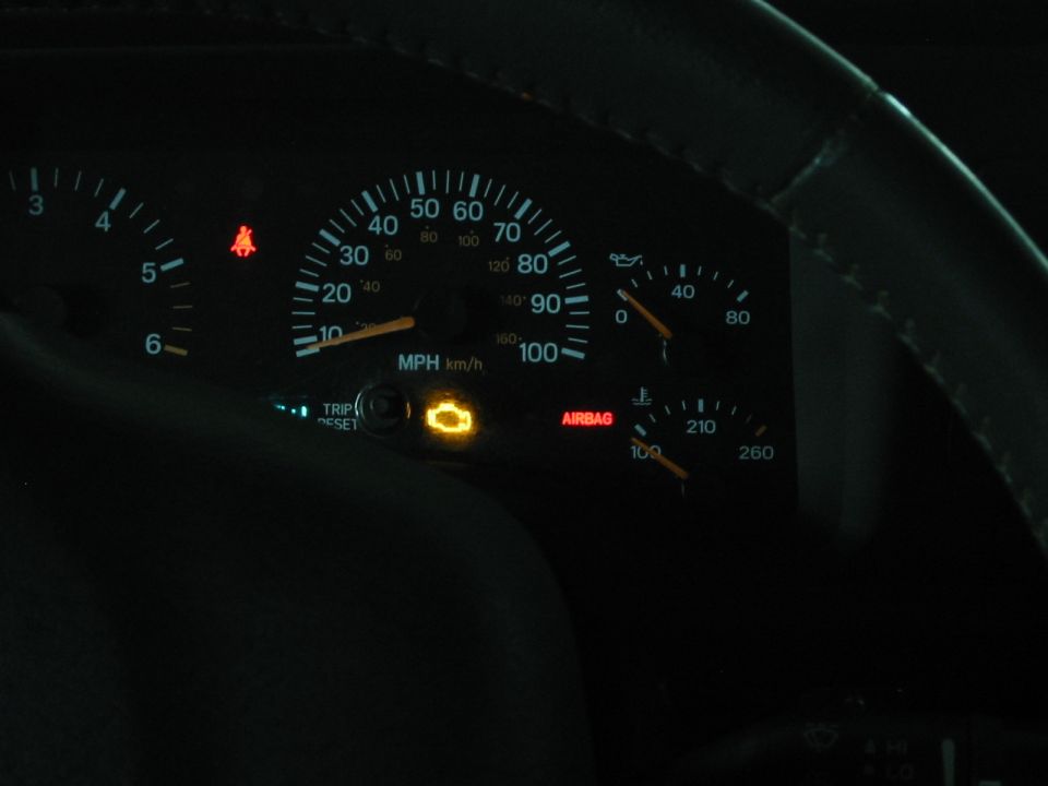 Dark gauge cluster with check engine, airbag and seatbelt warning lights lit