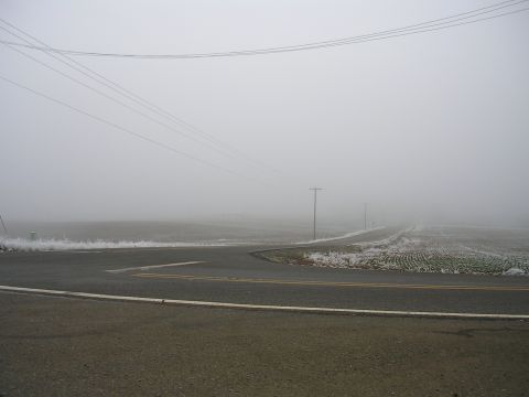 1996 Ford Probe - A foggy rural intersection with fields and power lines, suggesting a remote location.