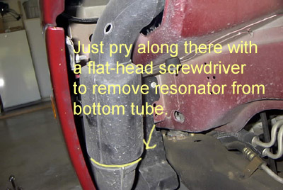 1999 Ford Taurus - Instructions overlayed on a car part, possibly for resonator removal.