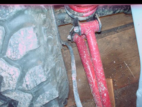1984 Ford Bronco - Close-up view of vehicle suspension components and a tire.